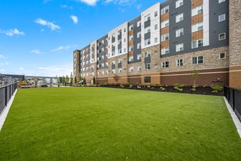 A large grassy area in front of a multi-story building.